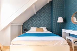 a bedroom with a bed with a blue wall at Exceptional duplex at Disneyland Paris in Serris