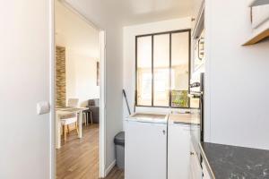 a kitchen with white cabinets and a dining room at Exceptional duplex at Disneyland Paris in Serris