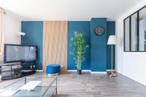 a living room with a tv and a blue wall at Exceptional duplex at Disneyland Paris in Serris