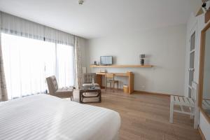 a hotel room with a bed and a table and chairs at Logis Le Château de Sable in Porspoder