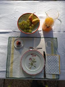 a table with a plate of fruit and a drink at Casa Quadrilumi B&B in Imola