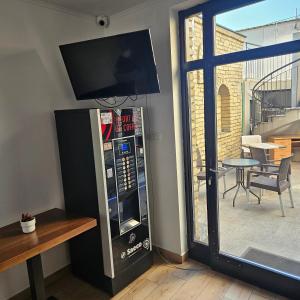 a soda machine with a television on top of it at IMAGINATOR RESIDENCE-Pool is extra pay- Parking 2 free space in Novi Sad