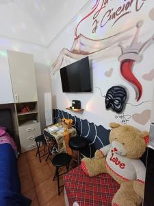 a room with a teddy bear sitting on a bed at la casetta di ciacione piazza del plebiscito in Naples