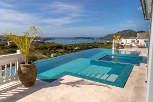 a pool with a view of the ocean from a house at Tuckers Villa in Cobbs Cross