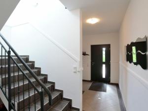 a hallway with a staircase and a black door at Serene Villa in Medebach K stelberg near Lake in Medebach