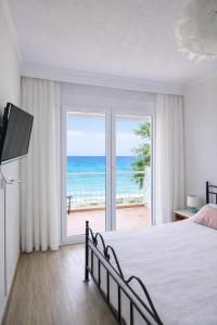 a bedroom with a bed and a view of the ocean at Ethereal Beach House in Hanioti