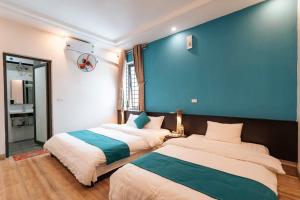 two beds in a room with a blue wall at Ha Giang SkyPath Hostel & Tours in Làng Lap