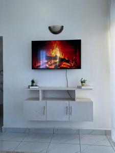 a living room with a tv on a white wall at Skyview Bamburi Suites in Mombasa