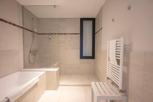 a bathroom with a tub and a shower and a sink at Logis Le Château de Sable in Porspoder +36 photos