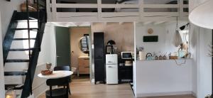 a kitchen with a white refrigerator and a table at Chez Ariel et Myrtille in Bruyères