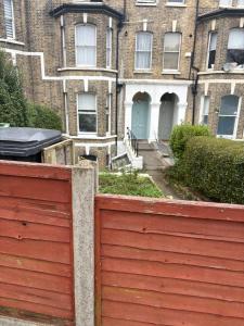 a red fence in front of a brick building at Crystal in Crystal Palace