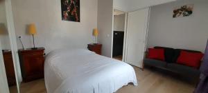a bedroom with a white bed and a couch at Haut de villa calme, 2 chambres et vue dégagée - proche calanques in Roquefort-la-Bédoule