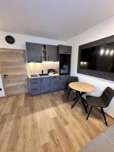 a kitchen with a wooden table and a table and chairs at Alpin Studio Haus, Kaibling & Ski amadé in Haus im Ennstal