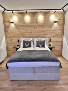 a bedroom with a large bed with wooden walls at Alpin Studio Haus, Kaibling & Ski amadé in Haus im Ennstal