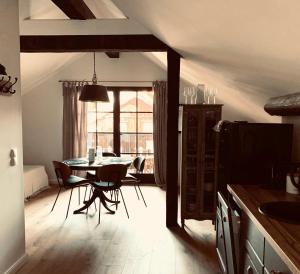 a kitchen with a table and chairs and a window at undfein boutique studios in Sankt Gilgen