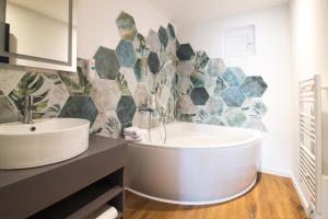 a bathroom with a tub and a sink at Cit'Hotel L'Oasis d'Avignon in Villeneuve-lès-Avignon +30 photos