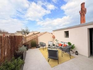 a patio with a table and chairs on a roof at Maison familiale rénovée avec terrasse, 4 chambres, proche L'Isle-sur-la-Sorgue in Pernes-les-Fontaines