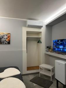 a room with a bed and a flat screen tv at La casa di Sesè in Viagrande