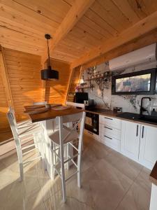 a kitchen with a wooden ceiling and a table and chairs at Vila Ahouse in Jagodina