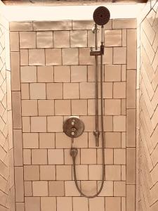 a shower in a bathroom with white tiles at undfein boutique studios in Sankt Gilgen +43 photos