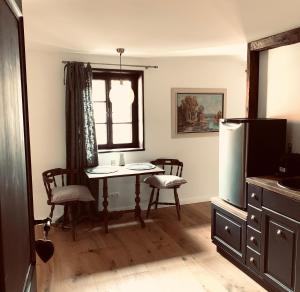 a kitchen with a table and chairs and a refrigerator at undfein boutique studios in Sankt Gilgen