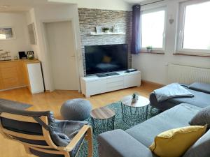 a living room with a couch and a tv at Ferienwohnung am Sendberg in Frielendorf