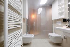 a white bathroom with a toilet and a sink at Haven Loft Como - Private Spa, Parking & Jacuzzi in Como