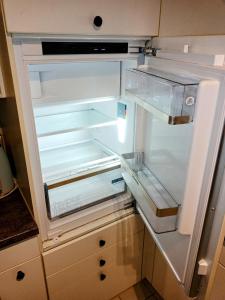 an empty refrigerator with its door open in a kitchen at Central 2, nice two room apartment, free bus, city tax included in Lucerne +11 photos