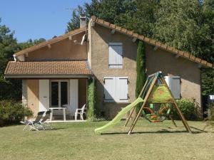 a house with a playground with a slide in the yard at Modern vacation home with private garden in Bathernay