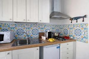 a kitchen with a sink and a stove top oven at Spinuzza Boutique Guesthouse Cefalù, Sicily in Cefalù