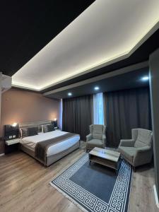 a bedroom with a bed and two chairs and a table at The Montana City Hotel in Bostaniçi