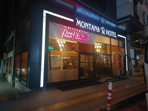 a store with a neon sign in front of it at The Montana City Hotel in Bostaniçi
