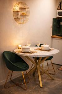 a table with two plates and wine glasses on it at La Chic Opéra - à 30 secondes min du Vieux-Port- Clim in Marseille +21 photos