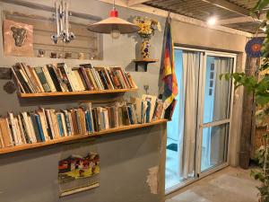 a shelf of books on a wall with a window at "La Violeta" casa con jardín, San Pedro in San Pedro