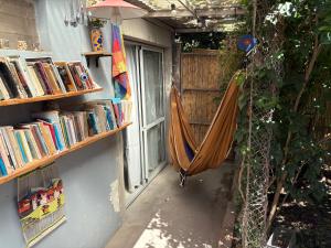 a porch with a hammock and a window with books at "La Violeta" casa con jardín, San Pedro in San Pedro