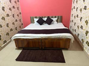 a bed with black and white pillows in a bedroom at Karuna Homestay in Ujjain