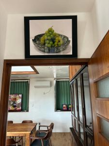 a painting of a bowl of green grapes on a wall at Cottage Tasuki in Nakijin