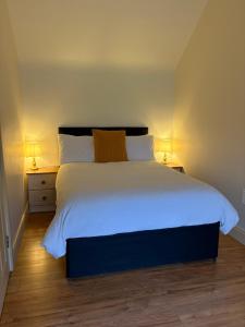 a bedroom with a large white bed with two lamps at Hidden Hills Waterville - Private Farmhouse in Waterville