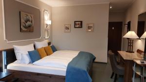 a hotel room with a bed with blue and yellow pillows at Hotel Weiße Taube in Döbeln +24 photos