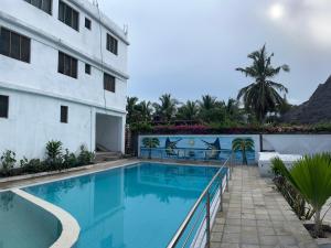 a swimming pool next to a building at Azure Coast retreat in Watamu +4 photos