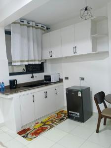 a kitchen with white cabinets and a plate of food on the floor at Bluu Diani in Diani Beach