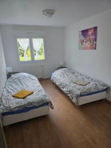 a bedroom with two beds and a window at 15 min A7, idéal Pro, Nuit Étape & invités événement in Cléon-dʼAndran