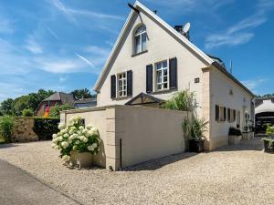 a large white house with a garage in a driveway at Ferienwohnung LA MAISON mit Sauna am See in Neuenkirchen