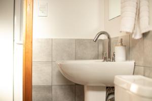 a bathroom with a white sink and a shower at Diez Pinos in Punta del Este +33 photos