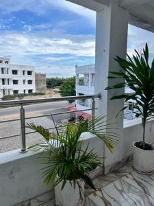 a balcony with two potted plants and a street at Azure Coast retreat in Watamu