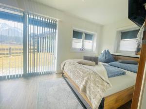 a bedroom with a bed and a large window at Apartment WEITBLICK in Wald im Pinzgau