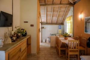a kitchen and dining room with a table and a television at Casa Coqueville - Charmosa, tranquila e cercada pela natureza em Itacaré in Itacaré