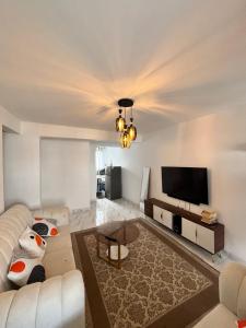 a living room with a couch and a flat screen tv at Azure Coast retreat in Watamu