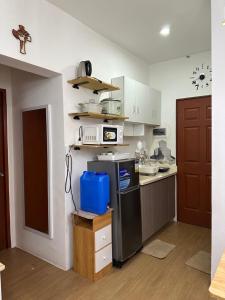a kitchen with white cabinets and a black refrigerator at Bayanihan Flats 2 in Pajak