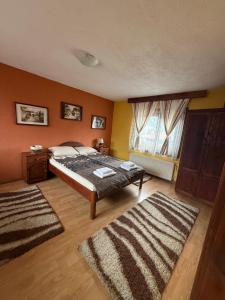 a bedroom with a bed and two rugs in it at Nenchova Guest House in Koprivshtitsa